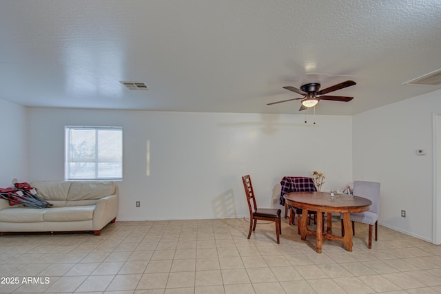 dining area with light tile patterned flooring, a ceiling fan, visible vents, and a textured ceiling