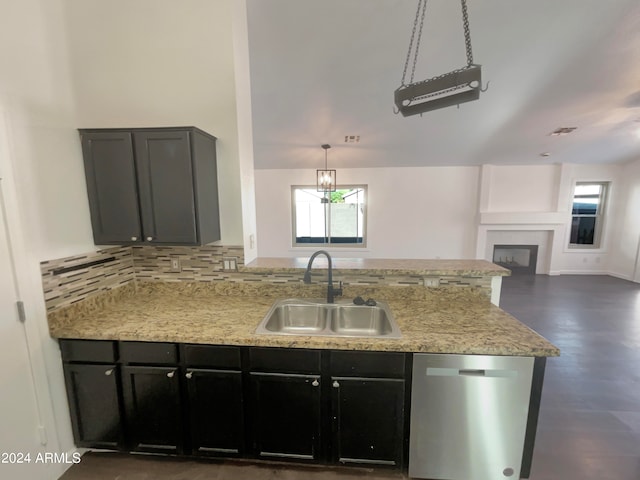 kitchen featuring a chandelier, sink, dishwasher, light stone countertops, and backsplash