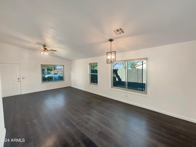 unfurnished living room with dark wood-type flooring, ceiling fan with notable chandelier, and lofted ceiling