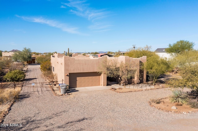 pueblo revival-style home with a garage