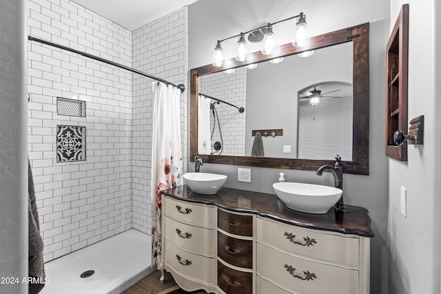 bathroom with walk in shower, ceiling fan, and vanity