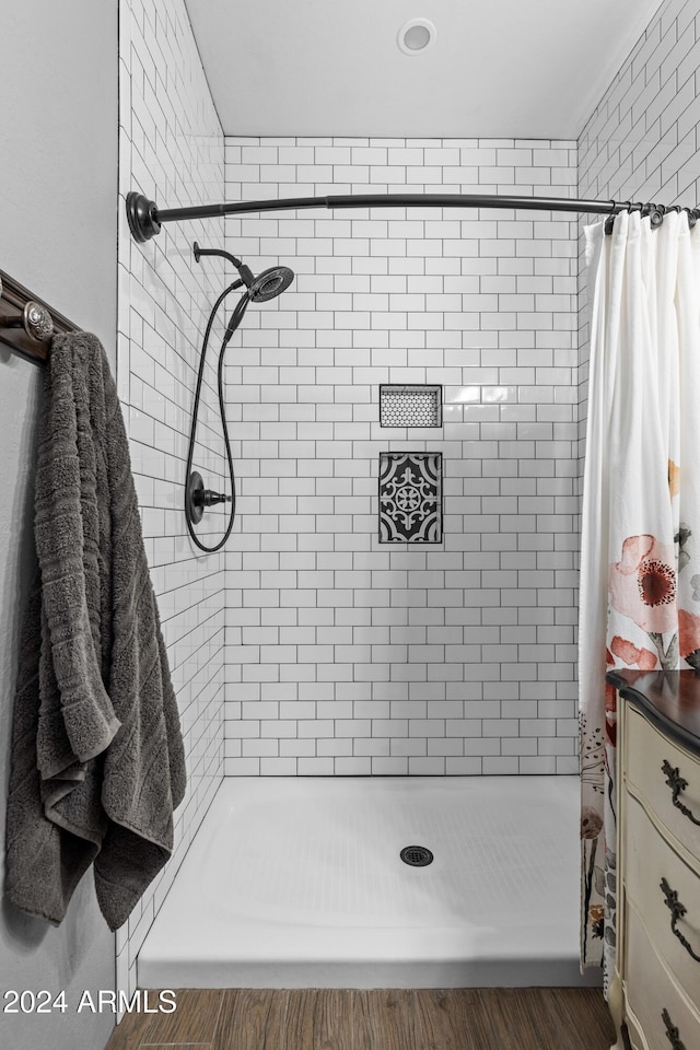 bathroom with a shower with shower curtain and hardwood / wood-style floors