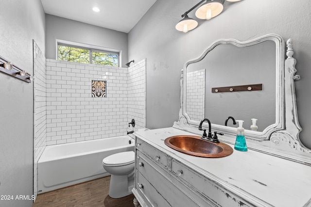 full bathroom with vanity, tiled shower / bath combo, and toilet