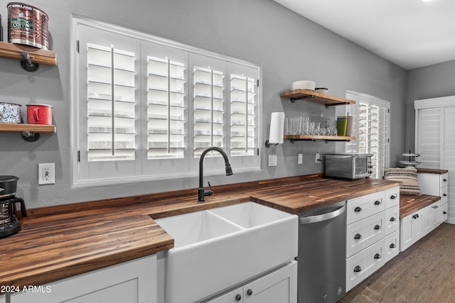 kitchen featuring wooden counters, white cabinets, and sink