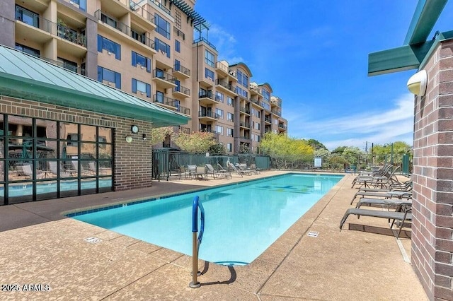 community pool featuring fence and a patio