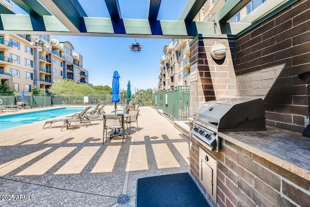 view of patio / terrace featuring a community pool, fence, and a grill