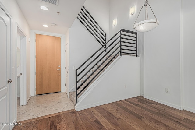 foyer entrance featuring recessed lighting, baseboards, light wood-type flooring, and stairs