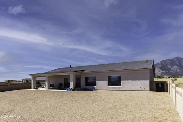 back of house with a mountain view and a patio