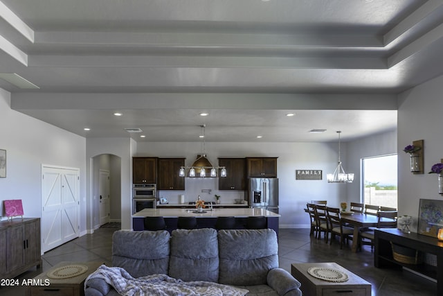 living room featuring a chandelier and dark tile patterned flooring