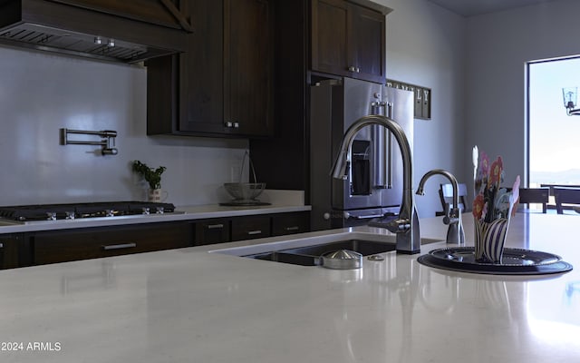 kitchen with gas cooktop, custom range hood, and stainless steel fridge with ice dispenser