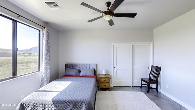 bedroom featuring a mountain view, a closet, and ceiling fan