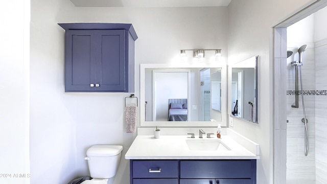 bathroom featuring vanity, toilet, and a tile shower