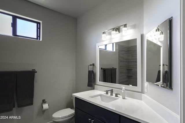 bathroom featuring vanity, a healthy amount of sunlight, and toilet