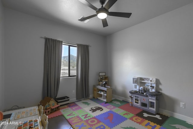 bedroom featuring ceiling fan and a mountain view