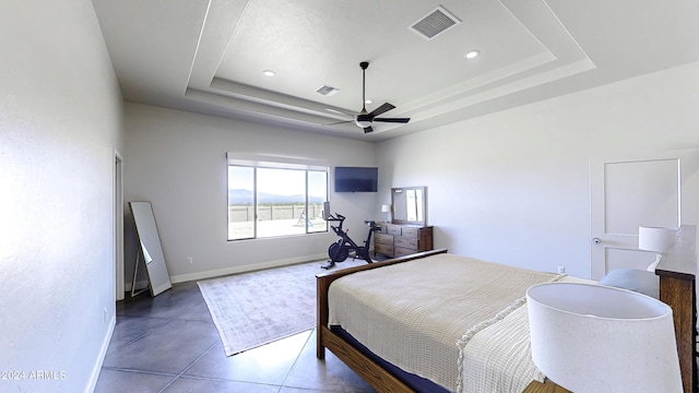 bedroom with a raised ceiling and ceiling fan