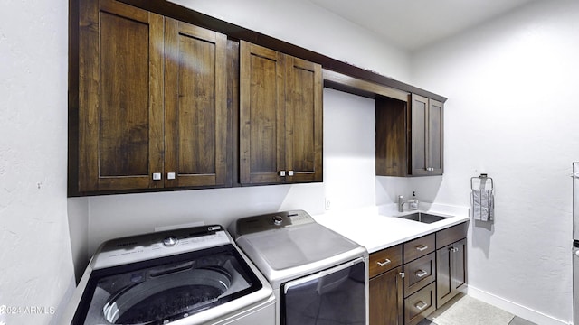 laundry room with washer and dryer, sink, light tile patterned flooring, and cabinets