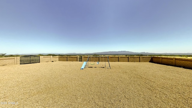 view of yard featuring a playground and a mountain view