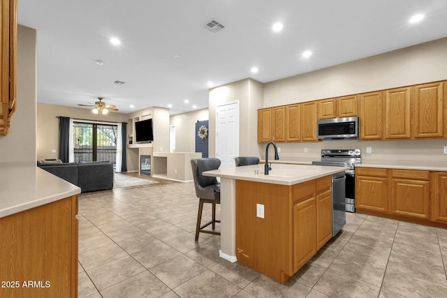 kitchen featuring visible vents, stainless steel appliances, light countertops, and open floor plan