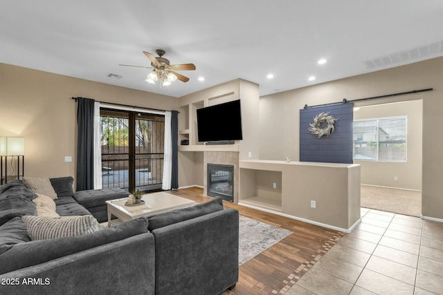 living area featuring visible vents, plenty of natural light, and a tile fireplace