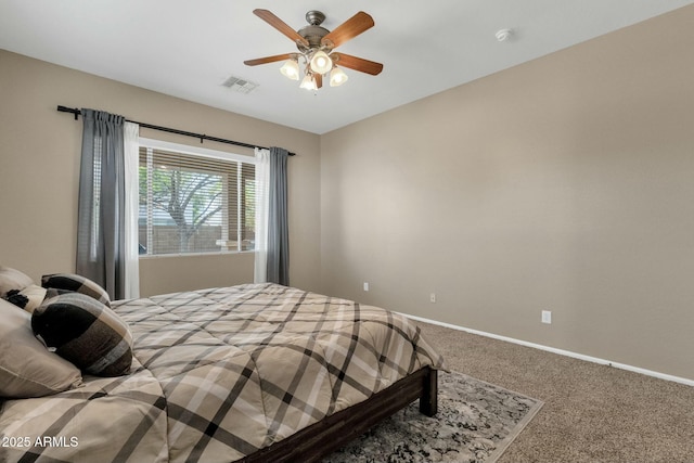 carpeted bedroom with visible vents, baseboards, and a ceiling fan