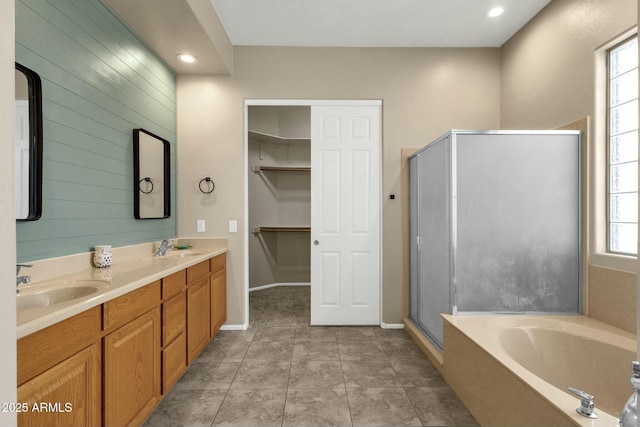 full bathroom featuring a sink, double vanity, a shower stall, and tile patterned flooring