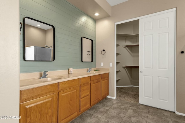 bathroom with tile patterned floors, a shower, double vanity, and a sink