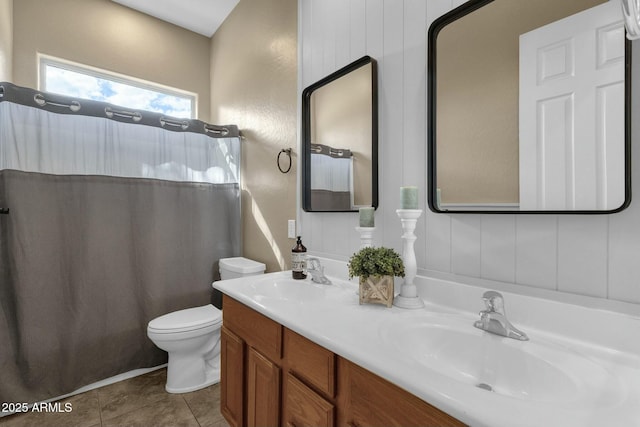 full bath with tile patterned floors, toilet, double vanity, and a sink