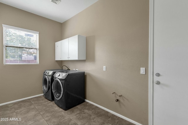 washroom featuring visible vents, cabinet space, light tile patterned floors, baseboards, and washing machine and clothes dryer