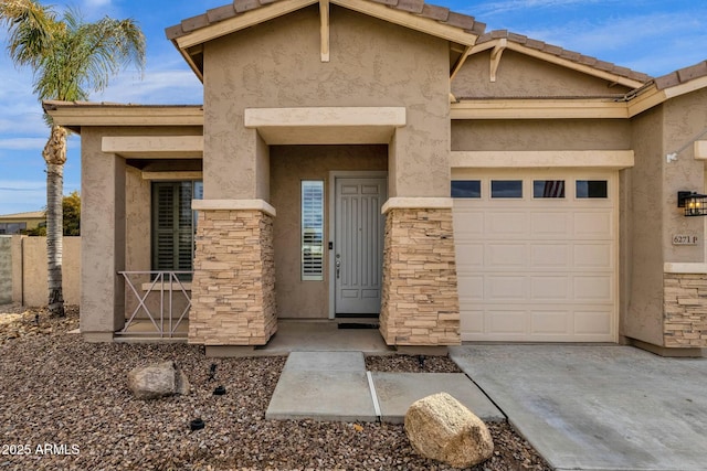 view of front facade with a tiled roof, concrete driveway, stucco siding, a garage, and stone siding