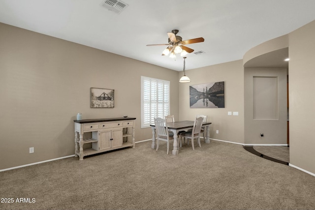 carpeted dining room with visible vents, baseboards, and a ceiling fan