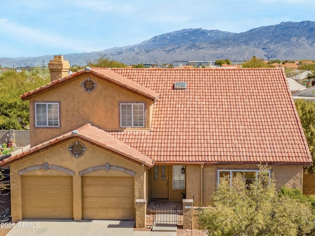 view of front of property with a mountain view and a garage