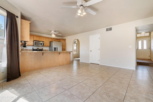 kitchen featuring appliances with stainless steel finishes, a breakfast bar area, light tile patterned floors, and kitchen peninsula