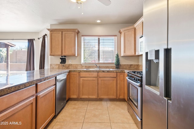 kitchen featuring light tile patterned flooring, ceiling fan, appliances with stainless steel finishes, and sink