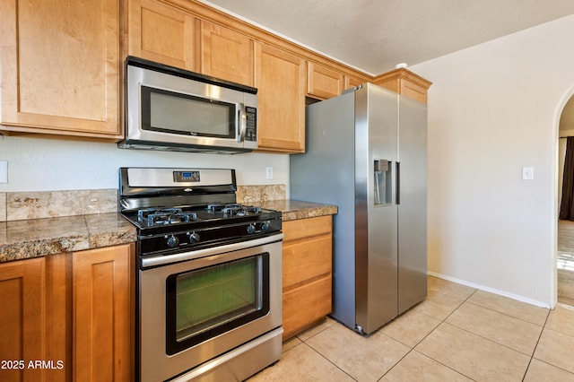 kitchen featuring light tile patterned flooring and appliances with stainless steel finishes