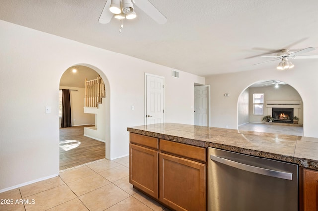 kitchen featuring ceiling fan, stainless steel dishwasher, and light tile patterned floors