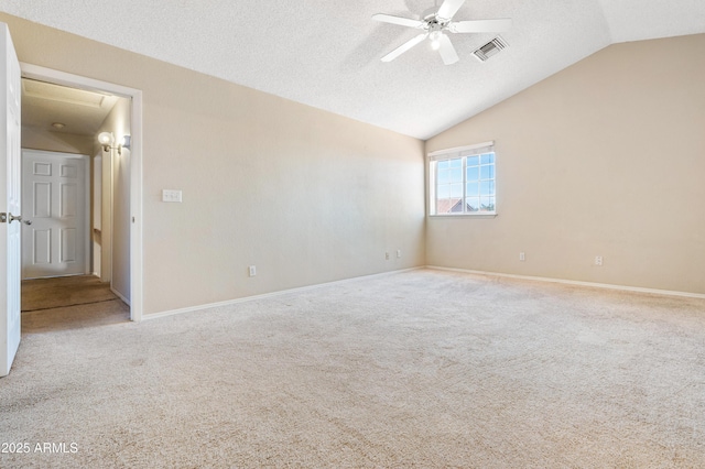 carpeted spare room with lofted ceiling, a textured ceiling, and ceiling fan