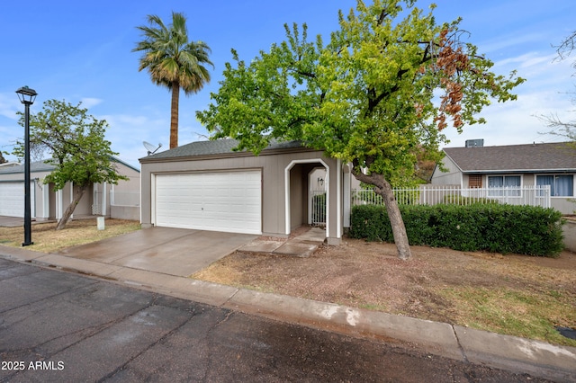 ranch-style house with an attached garage, concrete driveway, and fence