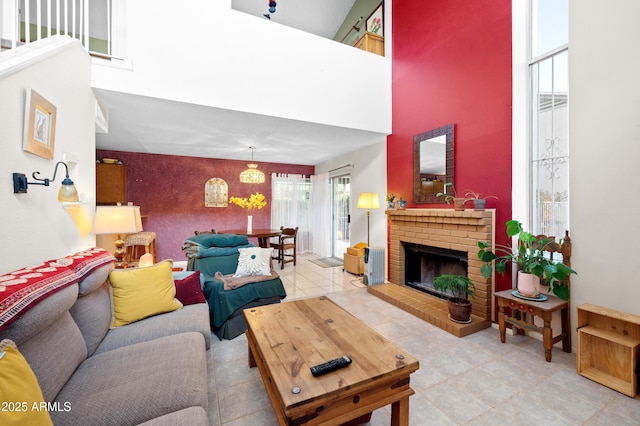 living area with an accent wall, a fireplace, and a towering ceiling