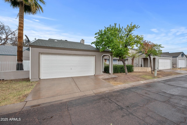 ranch-style house with a garage, concrete driveway, and a shingled roof