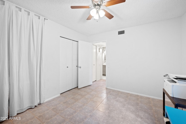 unfurnished bedroom with visible vents, a ceiling fan, a textured ceiling, a closet, and baseboards