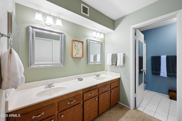 bathroom with double vanity, visible vents, tile patterned flooring, and a sink