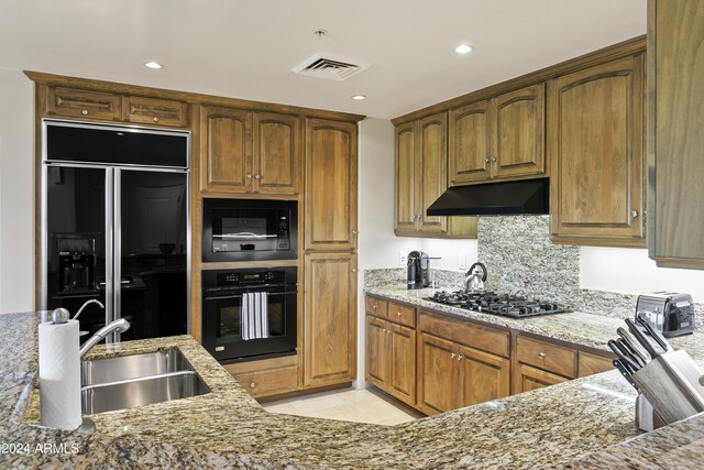 kitchen with tasteful backsplash, light stone countertops, sink, and black appliances