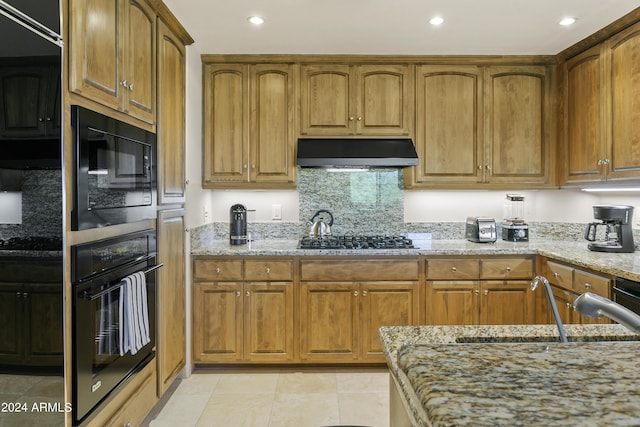 kitchen featuring black appliances, sink, decorative backsplash, light tile patterned floors, and light stone counters