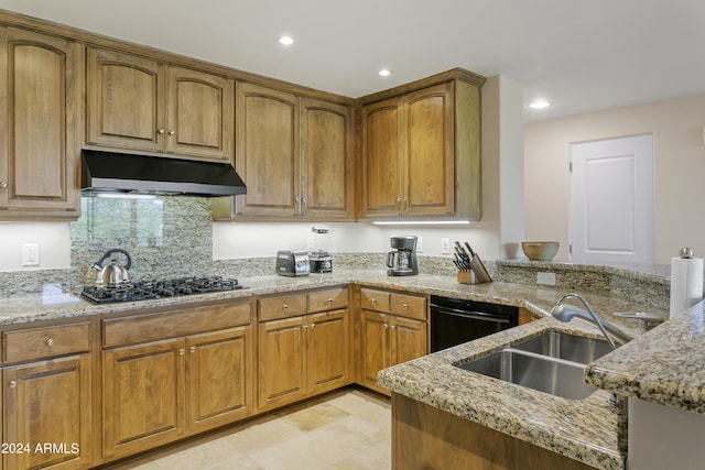 kitchen featuring tasteful backsplash, light stone counters, gas stovetop, sink, and dishwasher