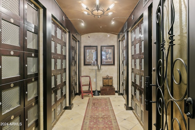 wine cellar featuring french doors, brick ceiling, light tile patterned floors, and vaulted ceiling