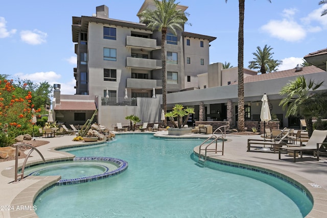 view of swimming pool featuring a patio and a hot tub