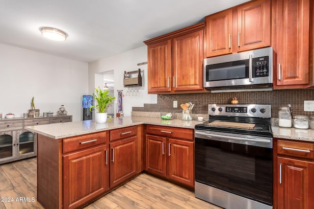 907 E 9th Ave, Mesa, AZ 85204 - kitchen featuring appliances with stainless steel finishes, a peninsula, backsplash, and light stone countertops