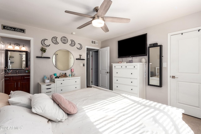 bedroom with ceiling fan, carpet floors, and ensuite bathroom