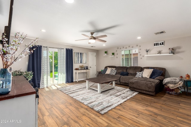 living room featuring ceiling fan, plenty of natural light, and hardwood / wood-style flooring