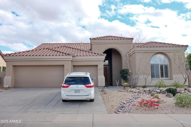 mediterranean / spanish-style house with a tile roof, a garage, driveway, and stucco siding